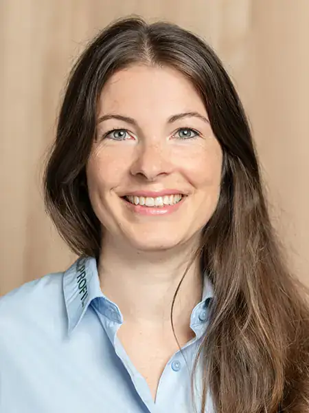 Portrait einer freundlich lächelnden Dame mit langem dunkelbraunem Haar
